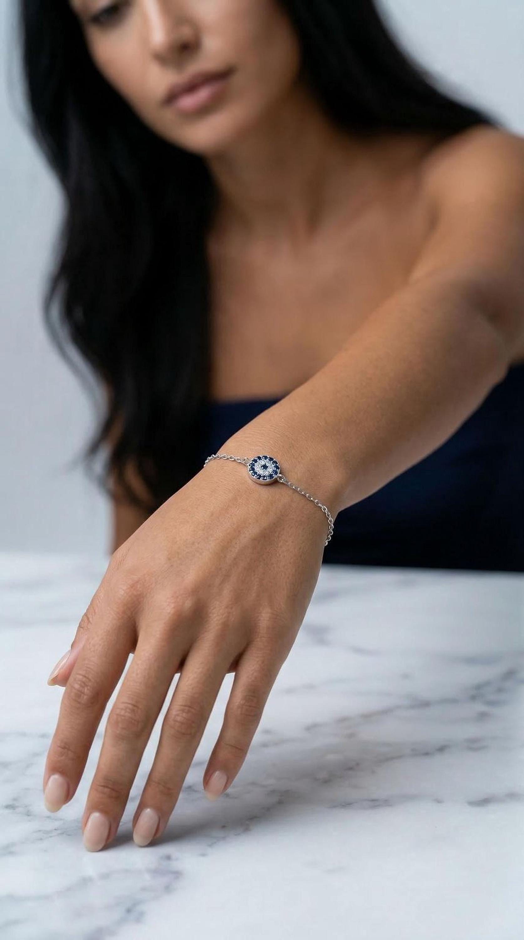 A woman wearing a bracelet with a blue and white design is sitting at a marble table.