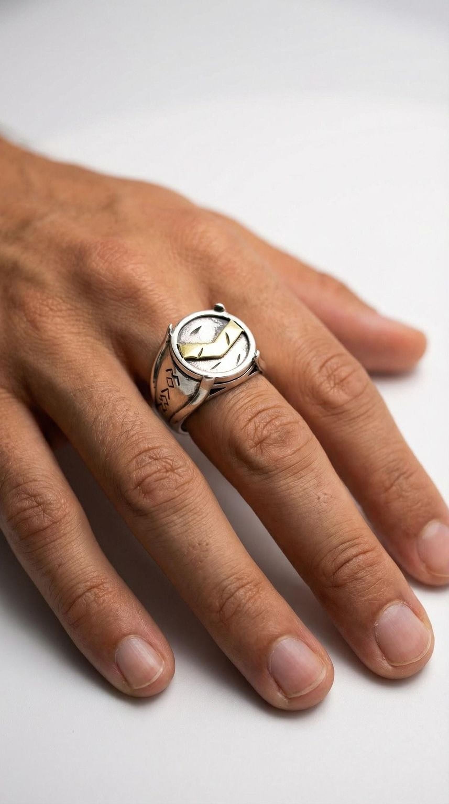 A close-up image of a person's hand wearing a silver ring with a unique design.
