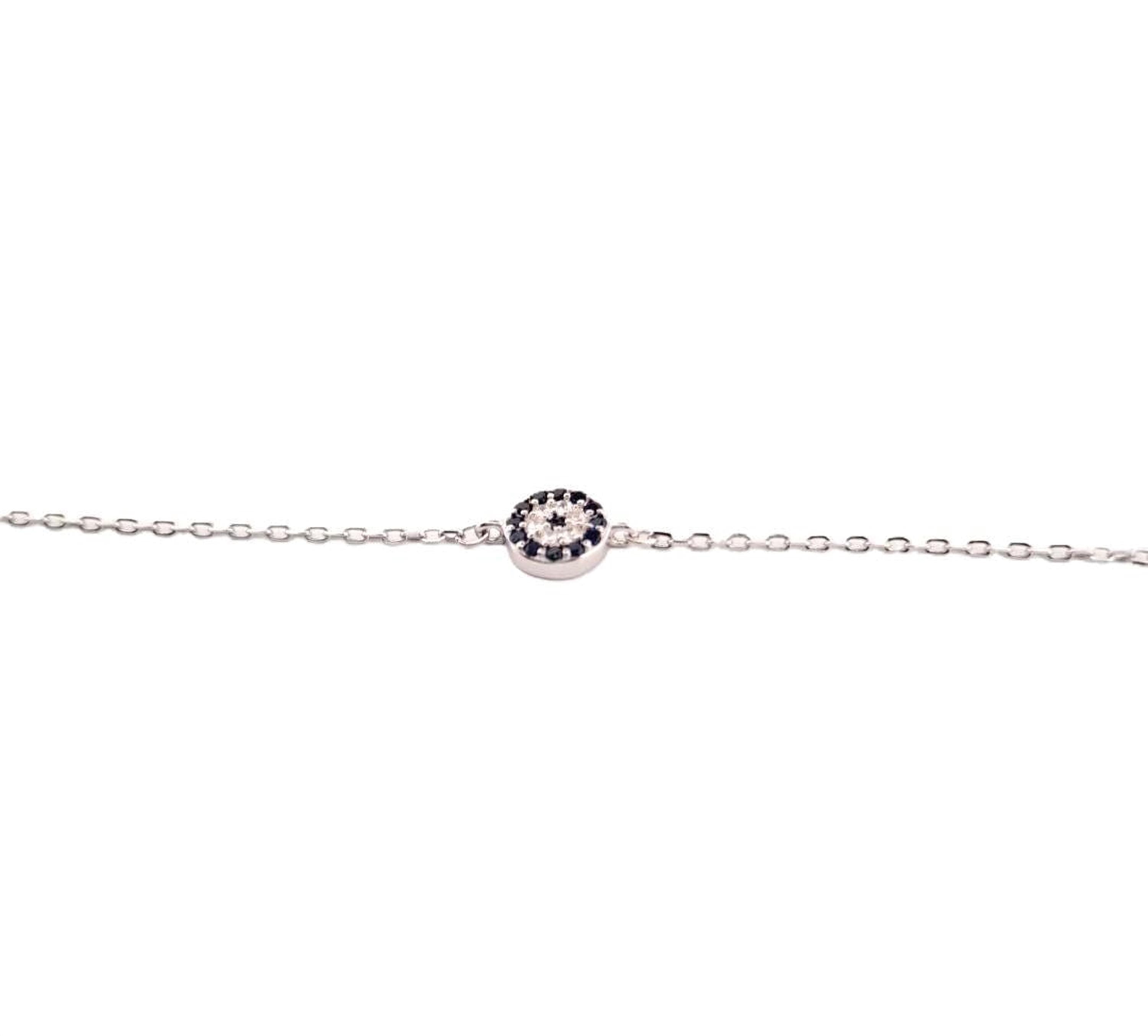 A silver necklace with a round pendant featuring a black gemstone.