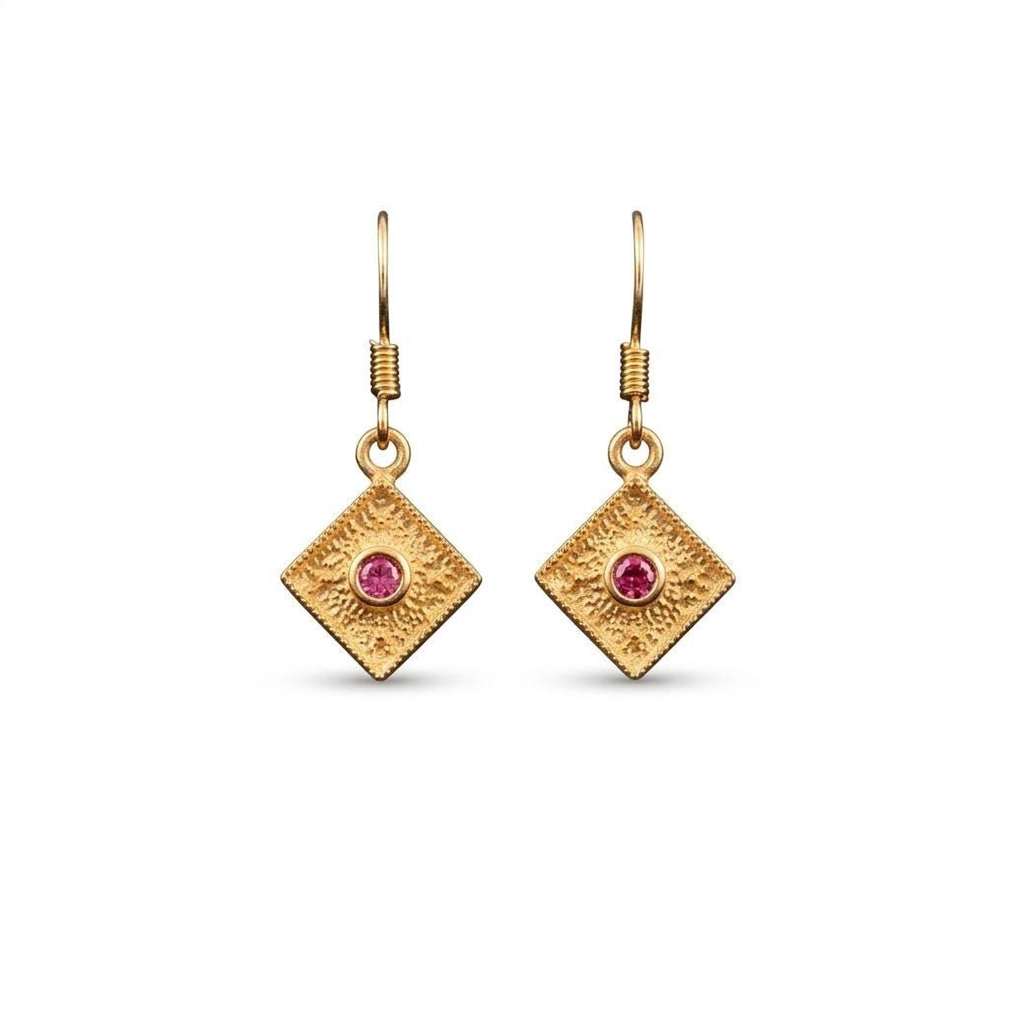 A pair of gold earrings with a diamond-shaped design and a pink gemstone in the center.
