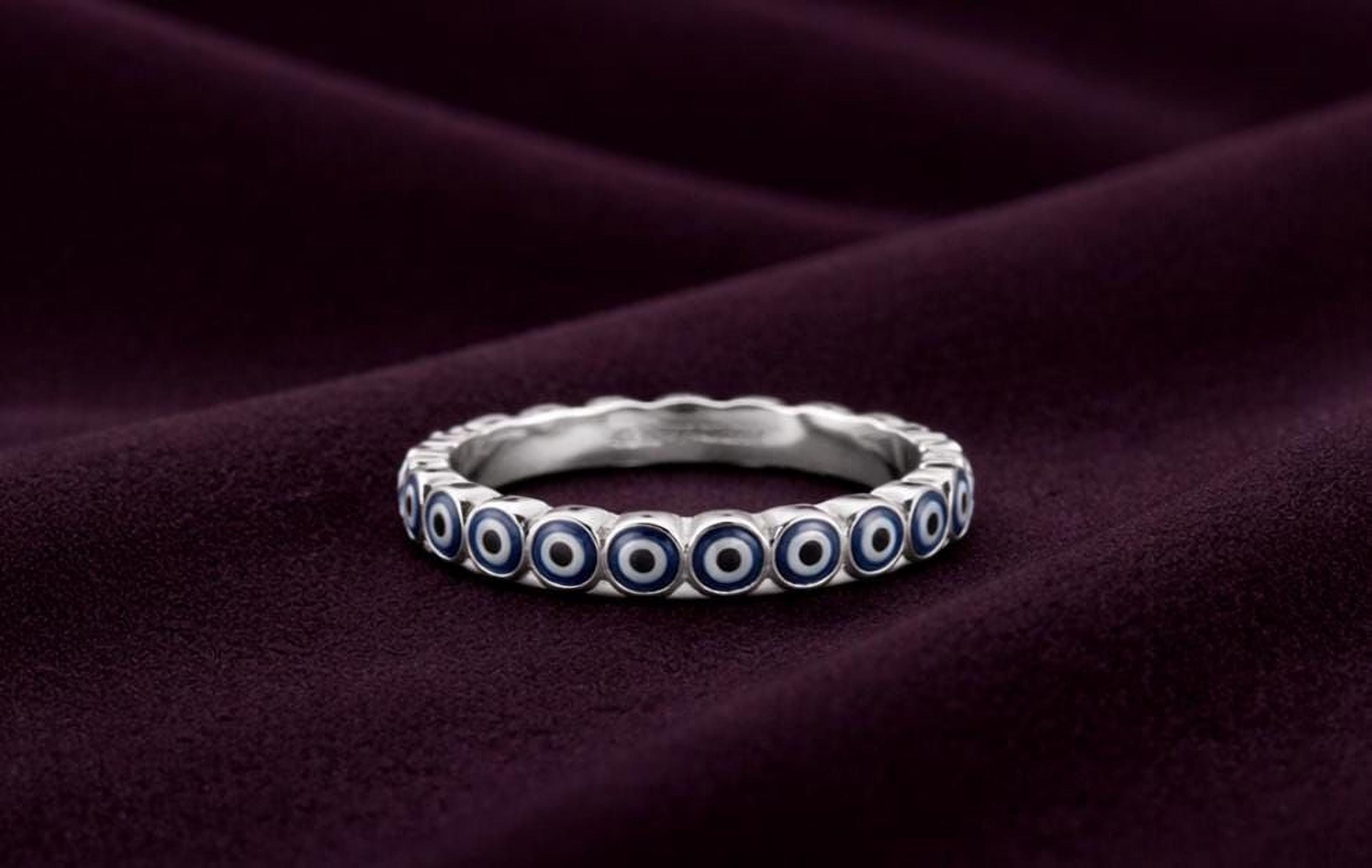 A silver ring with blue circles on a dark purple background.